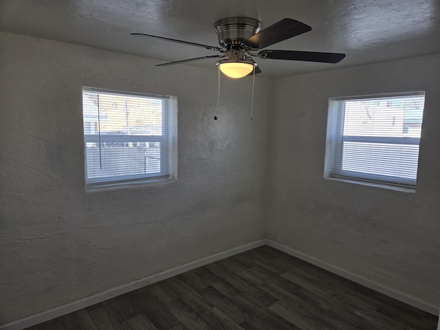 unfurnished room with plenty of natural light, dark wood-type flooring, and ceiling fan