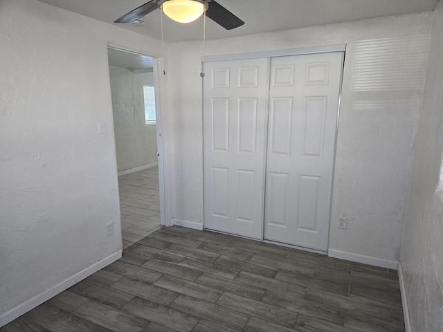 unfurnished bedroom featuring ceiling fan, dark hardwood / wood-style floors, and a closet