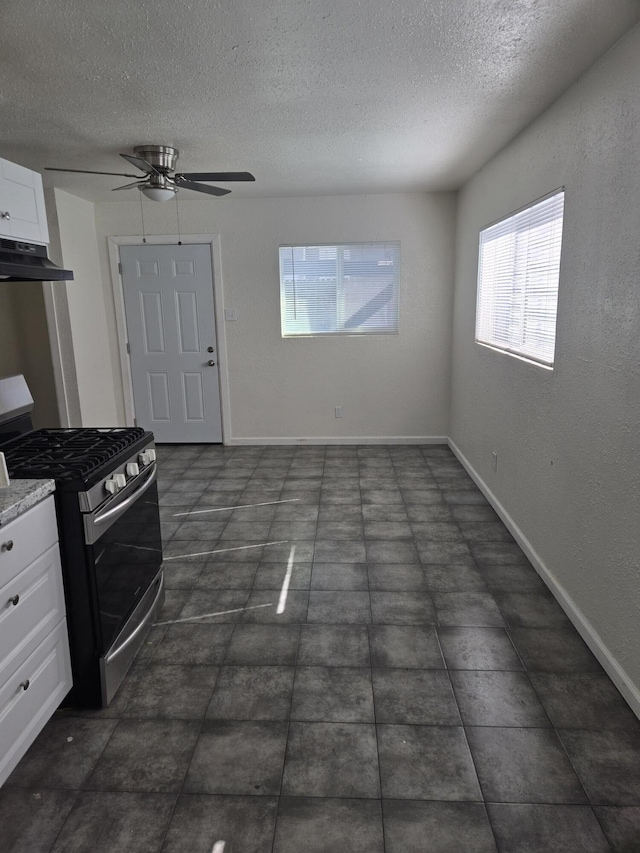 kitchen featuring white cabinetry, ceiling fan, a textured ceiling, and stainless steel gas stove