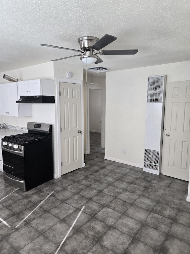 kitchen featuring white cabinets, a textured ceiling, stainless steel gas range, and ceiling fan