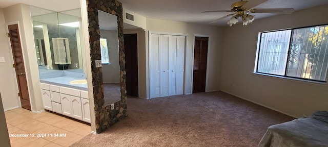 unfurnished bedroom with connected bathroom, light colored carpet, ceiling fan, and sink