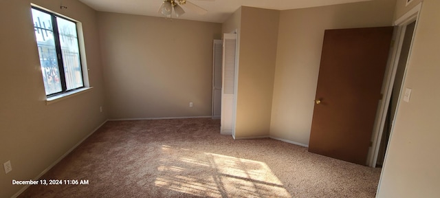 unfurnished bedroom with carpet flooring, multiple windows, and ceiling fan