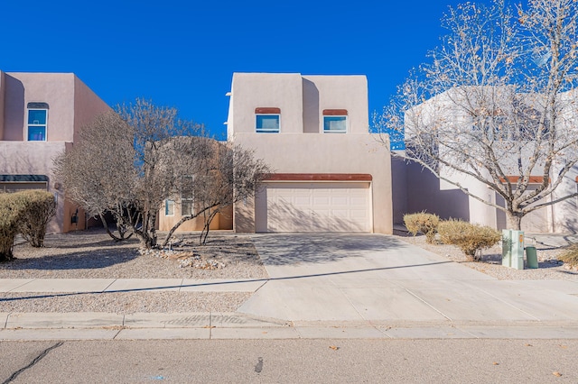 pueblo-style house featuring a garage