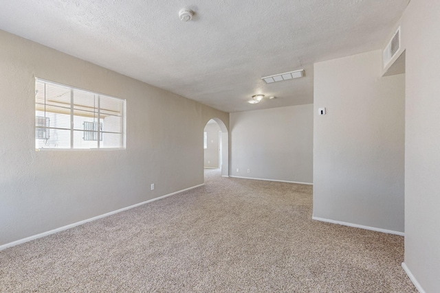 spare room featuring carpet floors and a textured ceiling