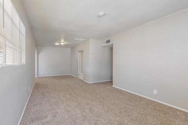 carpeted spare room featuring a textured ceiling