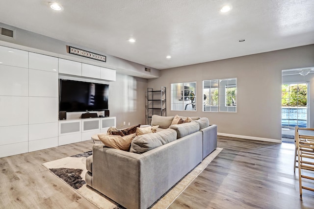 living room featuring a textured ceiling and light wood-type flooring