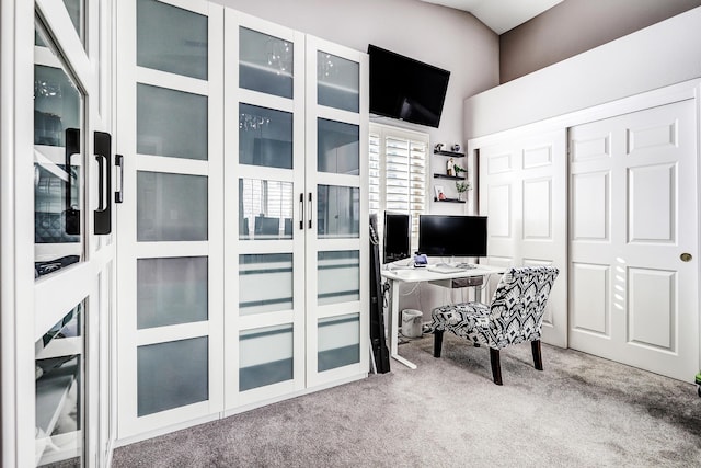 carpeted home office featuring vaulted ceiling