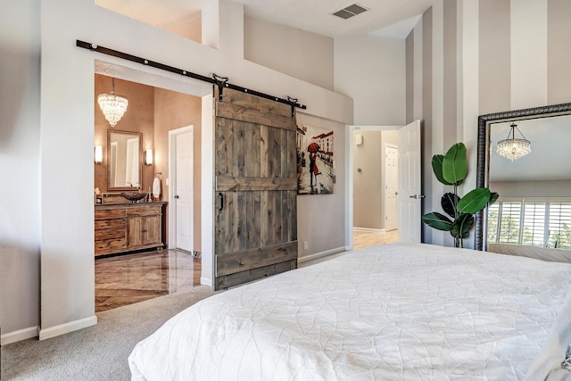 bedroom with a barn door, carpet floors, a high ceiling, and an inviting chandelier