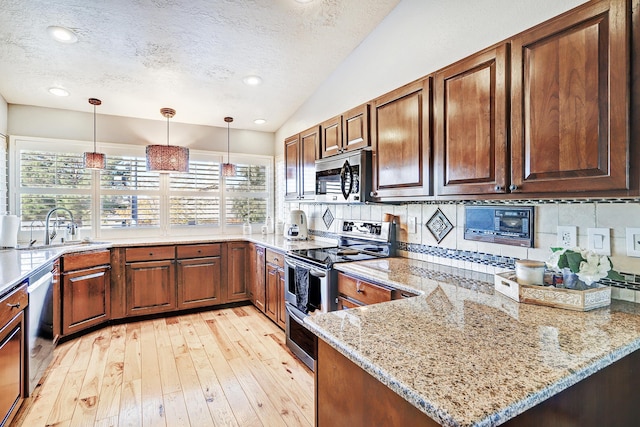 kitchen with stainless steel appliances, vaulted ceiling, tasteful backsplash, and a healthy amount of sunlight