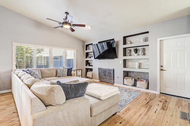 living room featuring hardwood / wood-style floors, ceiling fan, built in shelves, and vaulted ceiling