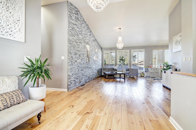 living room with hardwood / wood-style floors, high vaulted ceiling, and an inviting chandelier