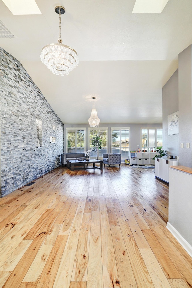 living room with hardwood / wood-style flooring, lofted ceiling, a wealth of natural light, and a chandelier