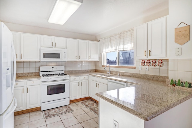 kitchen featuring white appliances, sink, kitchen peninsula, decorative backsplash, and white cabinetry