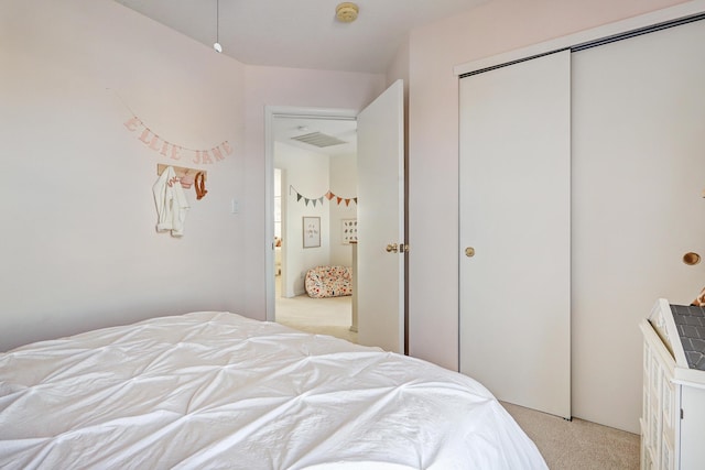 bedroom featuring light carpet and a closet