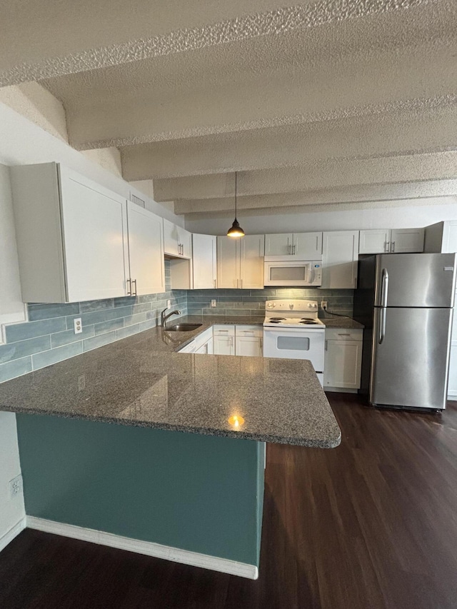 kitchen featuring white appliances, dark stone counters, white cabinets, a textured ceiling, and kitchen peninsula