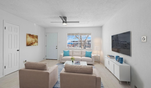 living room with ceiling fan and a textured ceiling