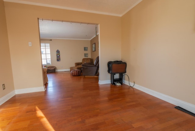 spare room featuring hardwood / wood-style floors and ornamental molding