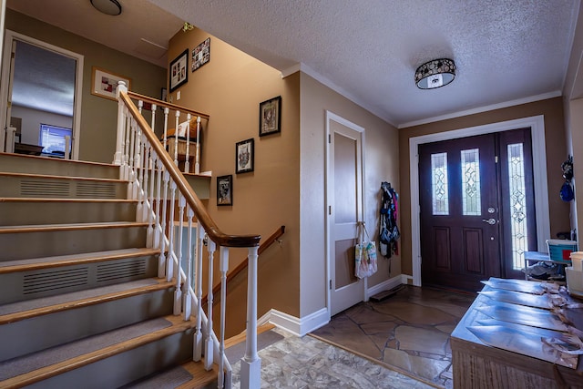 foyer entrance with a textured ceiling and ornamental molding