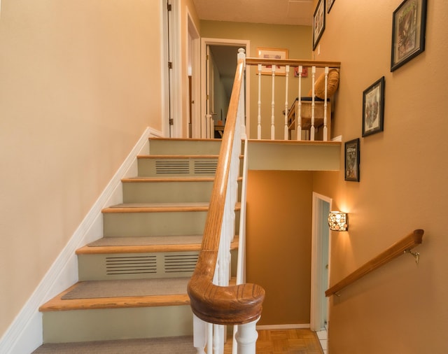 staircase featuring parquet floors