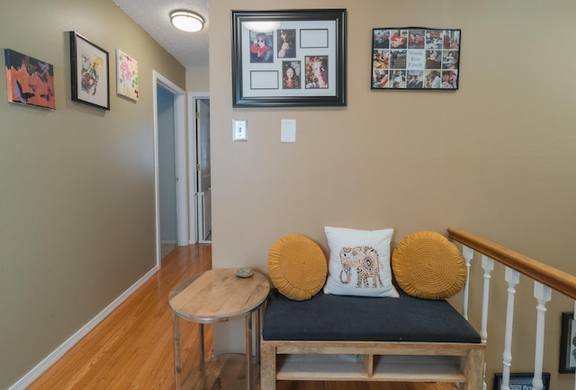 hall with wood-type flooring and a textured ceiling