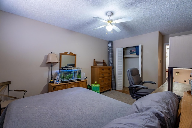 carpeted bedroom featuring ceiling fan, a textured ceiling, and a closet