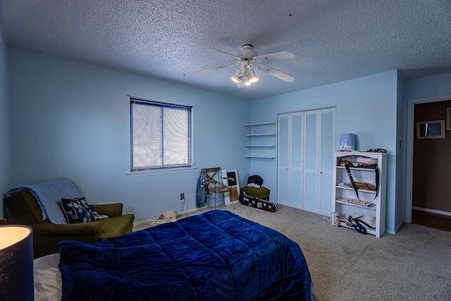 bedroom featuring a textured ceiling, carpet floors, a closet, and ceiling fan