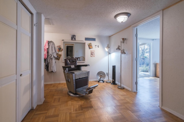 hall with light parquet floors and a textured ceiling