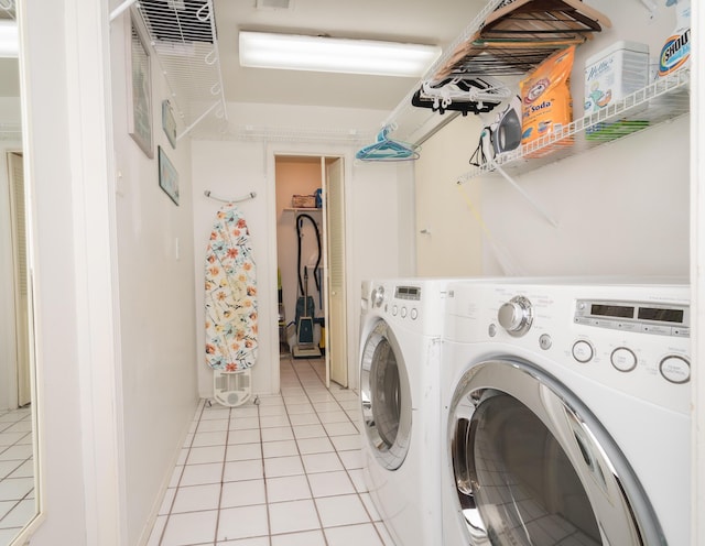 laundry area with light tile patterned floors and washer and dryer