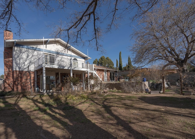 rear view of property featuring a deck and a yard