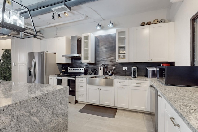 kitchen featuring white cabinets, sink, hanging light fixtures, wall chimney exhaust hood, and appliances with stainless steel finishes