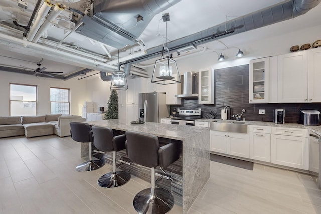 kitchen featuring pendant lighting, light stone countertops, sink, and stainless steel appliances