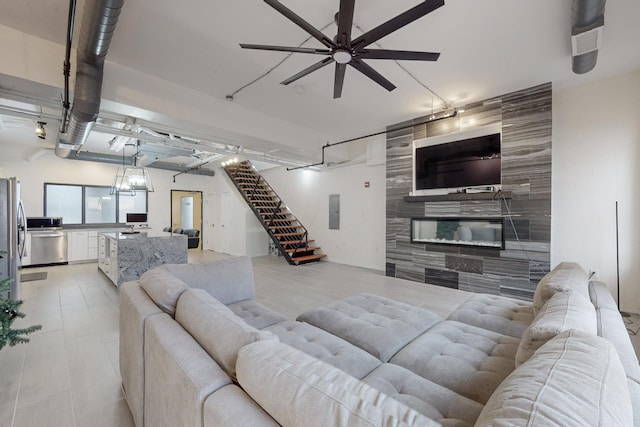 tiled living room with electric panel, ceiling fan, and a tiled fireplace