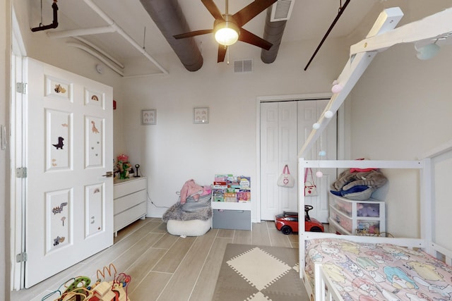 bedroom with ceiling fan, a closet, and light hardwood / wood-style flooring