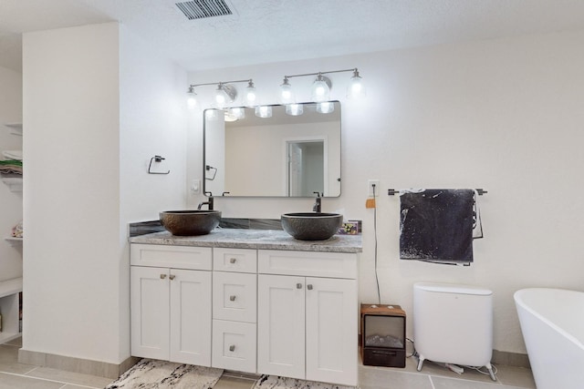 bathroom featuring a tub, tile patterned flooring, and vanity