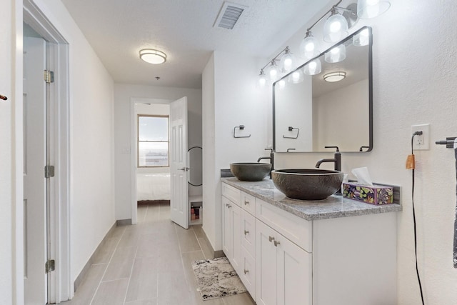 bathroom featuring vanity, a textured ceiling, and tile patterned flooring