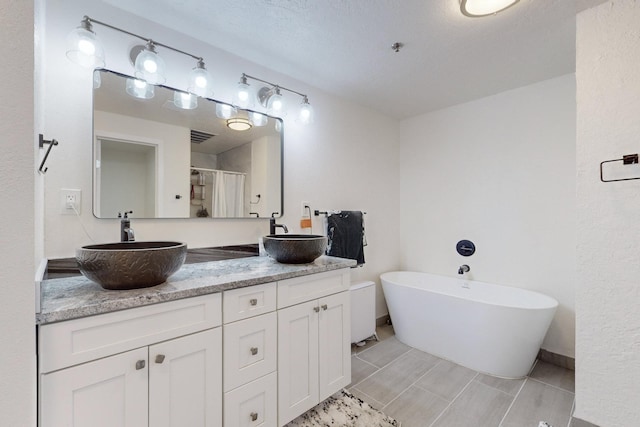 bathroom with plus walk in shower, tile patterned flooring, vanity, and a textured ceiling