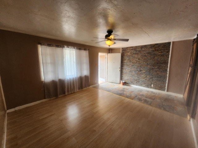 empty room with ceiling fan and hardwood / wood-style flooring