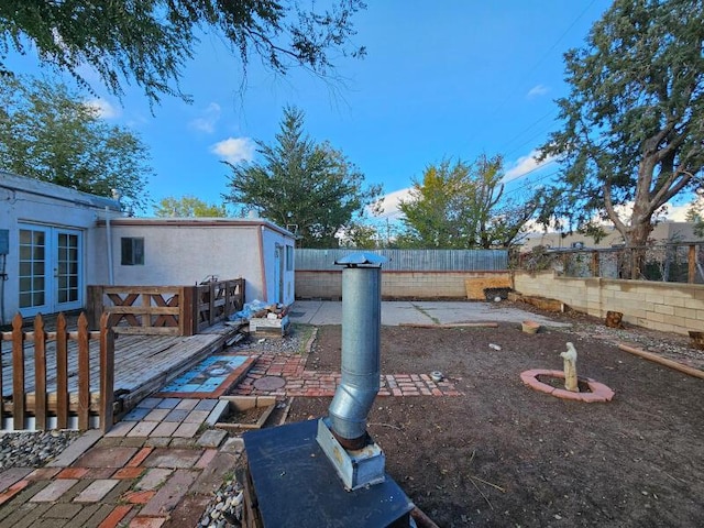 view of yard featuring a wooden deck and french doors