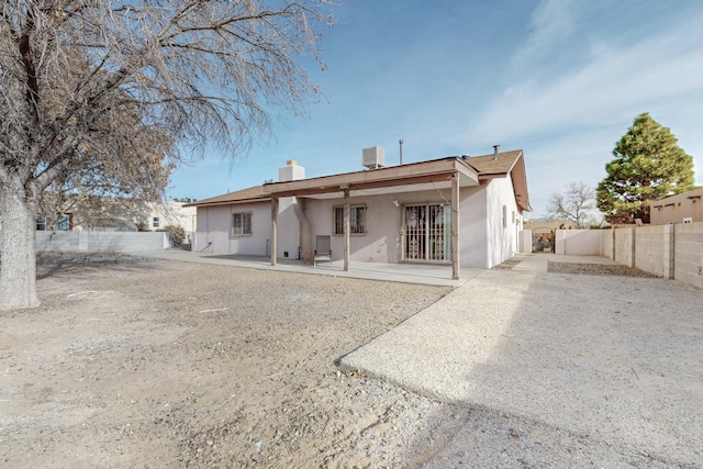 back of property with cooling unit and a patio area