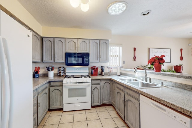 kitchen with sink, gray cabinetry, a textured ceiling, light tile patterned floors, and white appliances