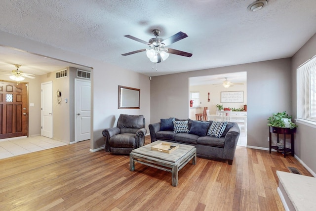 living room with a textured ceiling and light hardwood / wood-style flooring