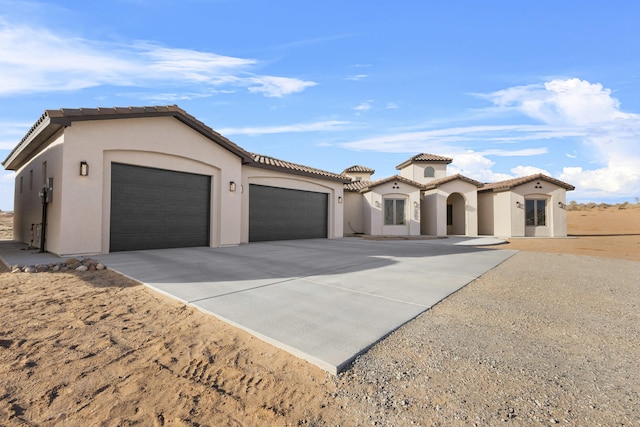 mediterranean / spanish home featuring a garage