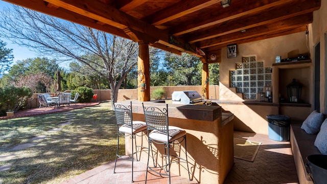 view of patio featuring area for grilling, exterior kitchen, and an outdoor bar