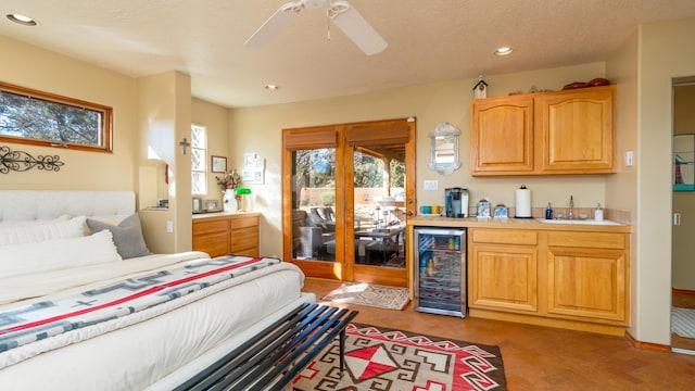 bedroom with ceiling fan, dark hardwood / wood-style floors, sink, and beverage cooler