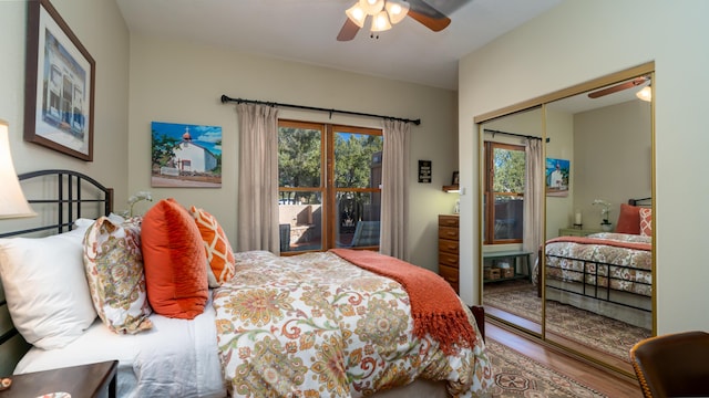 bedroom with hardwood / wood-style flooring, ceiling fan, multiple windows, and a closet