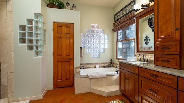 bathroom featuring vanity and tiled bath