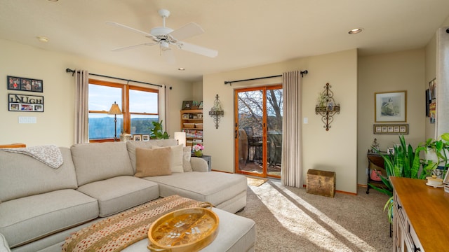 carpeted living room with ceiling fan