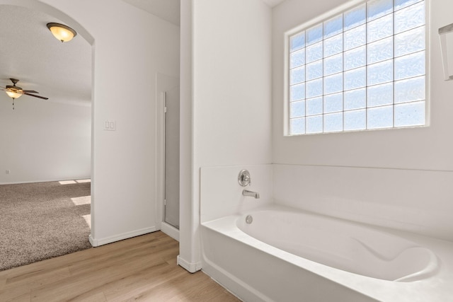 bathroom featuring hardwood / wood-style flooring, ceiling fan, a healthy amount of sunlight, and shower with separate bathtub