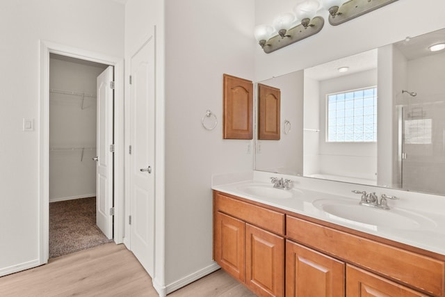 bathroom featuring hardwood / wood-style flooring, vanity, and walk in shower