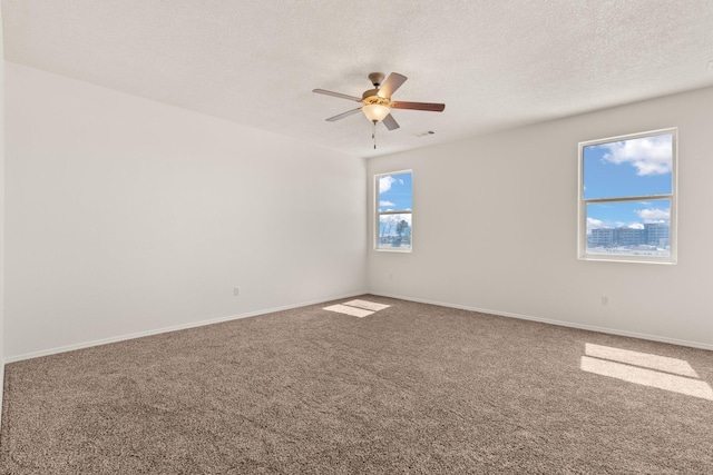 carpeted spare room featuring ceiling fan and a textured ceiling